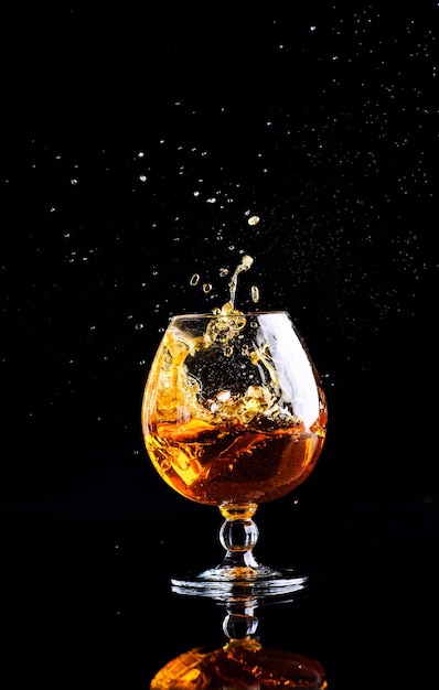 Glass with cognac on a black background