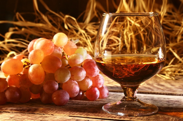 Glass with Cognac or Brandy and fresh grapes. 