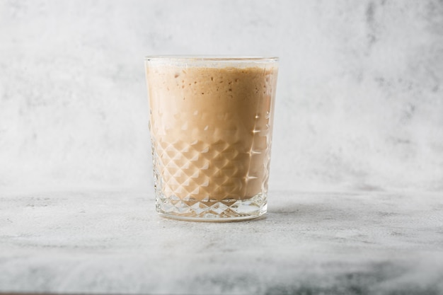 Photo glass with cold brew coffee and milk isolated on bright marble background. overhead view, copy space. advertising for cafe menu. coffee shop menu. horizontal photo.