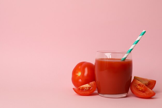 Glass with fresh tomato juice on pink