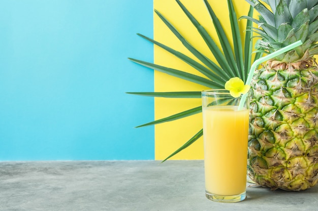 Glass with Freshly Pressed Pineapple Orange Coconut Juice Straw and Small Flower. 