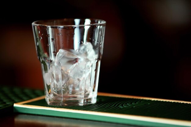 Glass with ice on bar counter