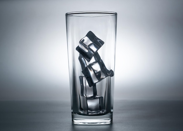Glass with ice, that makes one feel refreshed on blurred shadow background