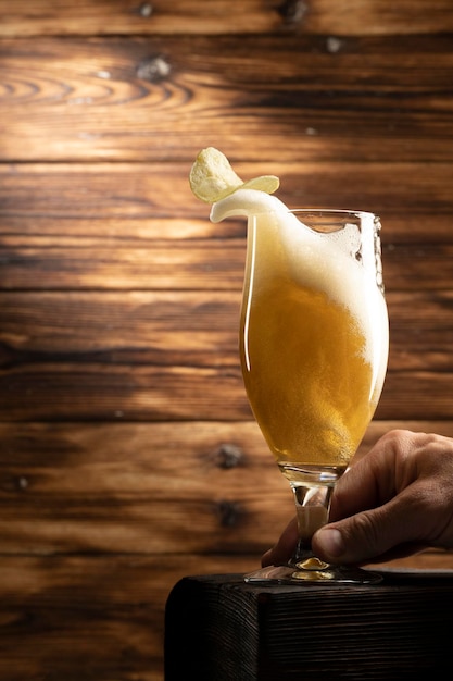 Glass with lager beer on wooden background