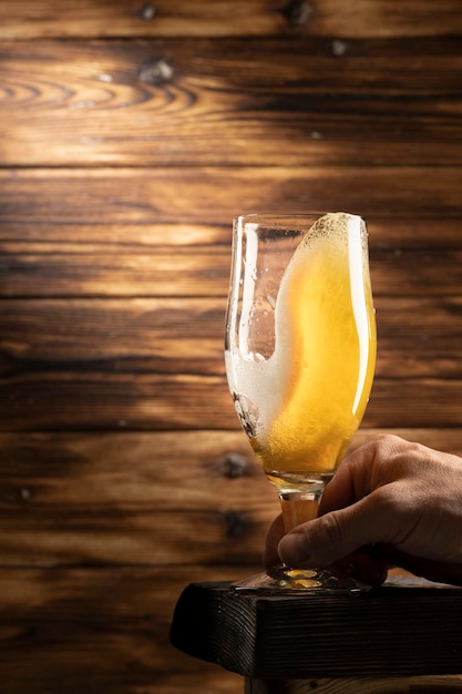 Glass with lager beer on wooden background.