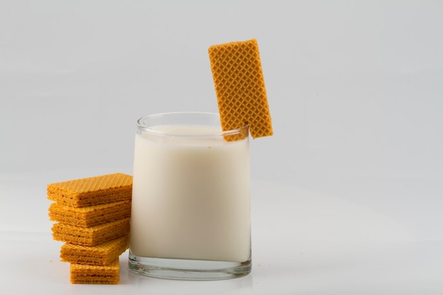 Glass with milk and wafer cookies isolated on white background