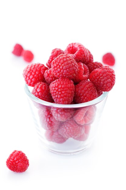 Glass with natural raspberries on a white background