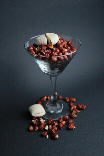 a glass with nuts and a small round object in it