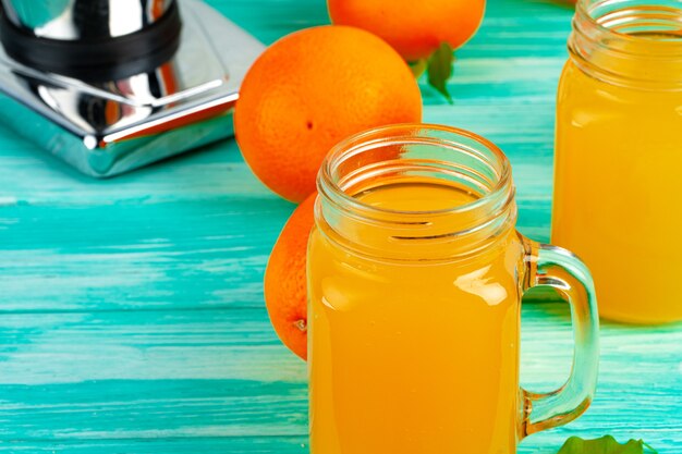 Glass with orange juice on green wooden table