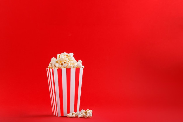 Glass with popcorn on a red background