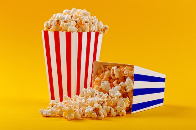 Glass with popcorn on a yellow background