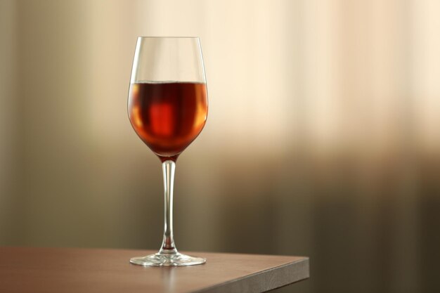 Glass with red wine on table