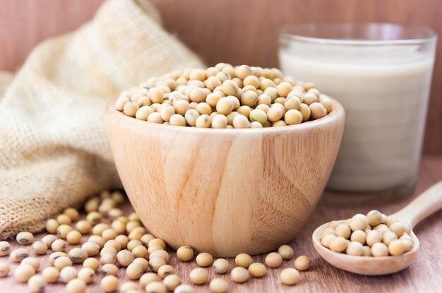 Glass with Soy Milk and beans on wooden background