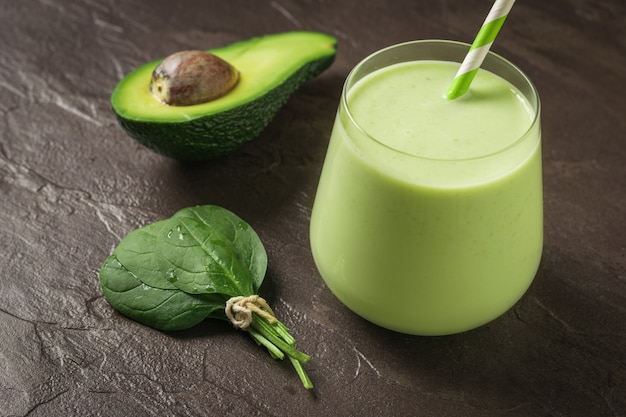 Glass with spinach and avocado smoothies on a stone background. Fitness product. Dietary sports nutrition.