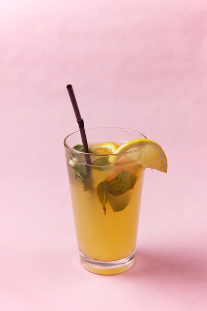A glass with a straw and a slice of lemon, a blurred surface
