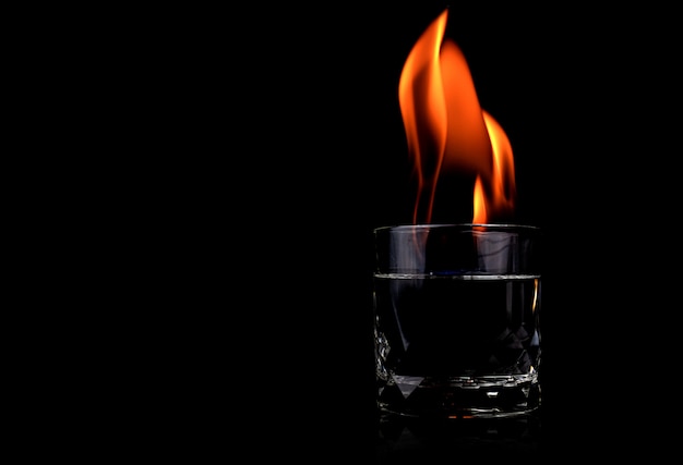 Glass with vodka and fire flame