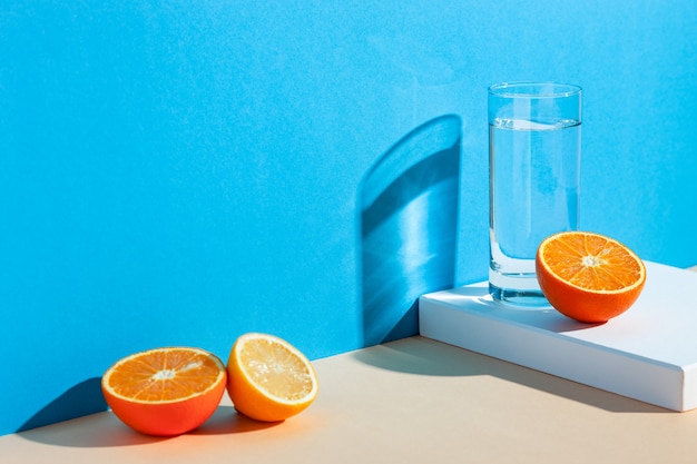  a glass with water, lemon and orange