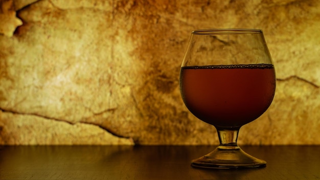 glass with wine on the table on vintage background