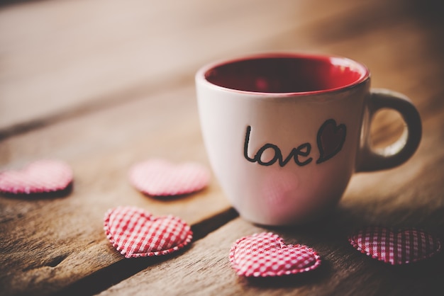 Glass with the words "Love" placed on the wooden floor