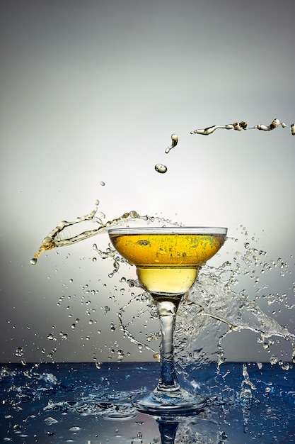 Bicchiere con champagne giallo o cocktail.