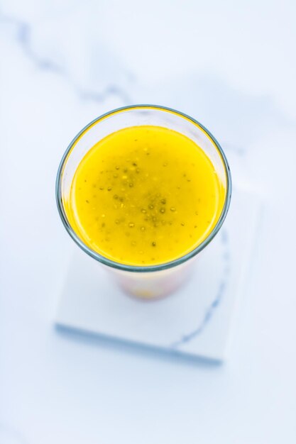 Glass of yellow fruit smoothie juice with chia seeds for diet detox perfect breakfast recipe