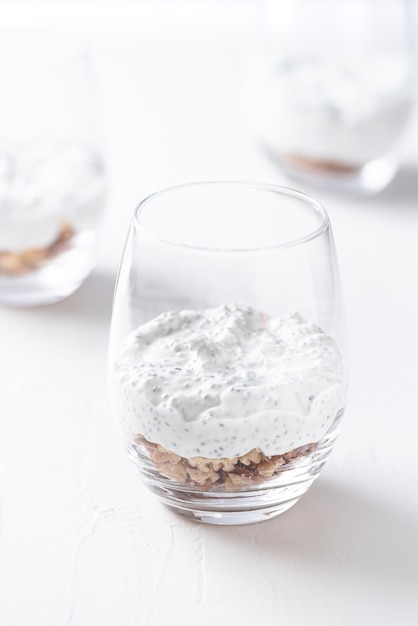 Photo glass of yogurt with chia, peanut cream and nuts