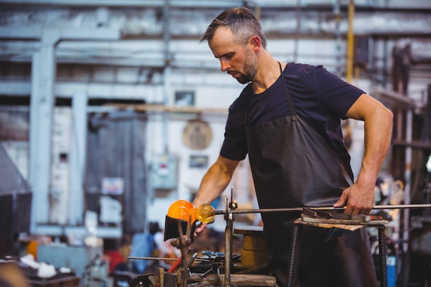 Glassblower forming and shaping a glass