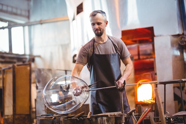 Glassblower shaping a molten glass