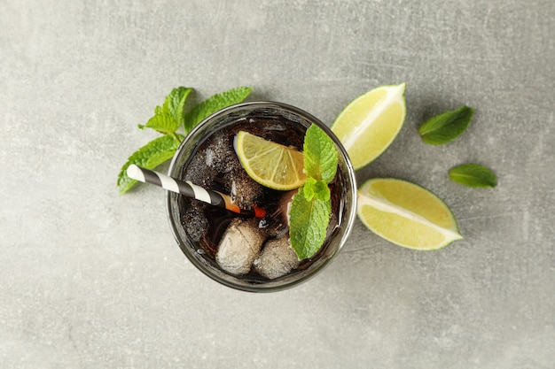 Glasse con cola fredda e agrumi sul tavolo grigio, vista dall'alto