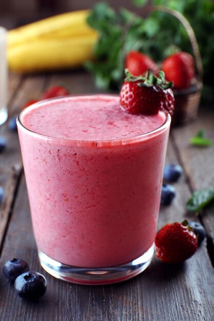 Foto glassen verse koude smoothie met fruit en bessen op houten achtergrond