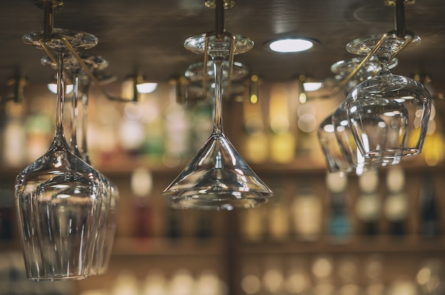 Glasses for alcoholic beverages are suspended above the bar.