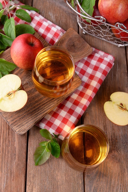 Glasses of apple juice on wooden background