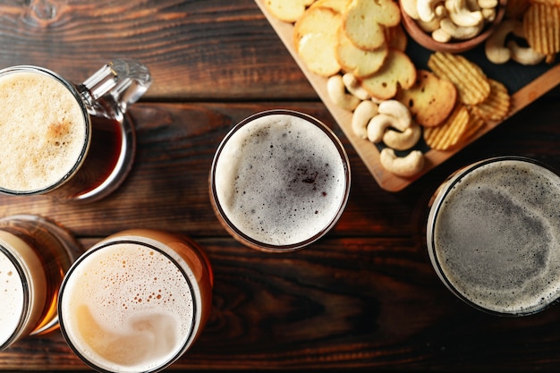 ビールと木製のテーブルで軽食のグラス