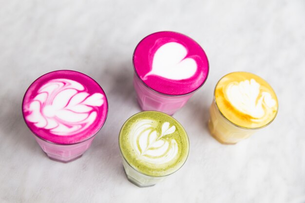 Glasses of beetroot, matcha,turmeric latte on marble table background. Trendy healthy drinks.