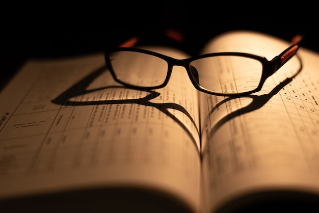 Glasses on the book on dark background.