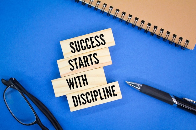 Photo glasses, books and pens with the words success starts with discipline. motivational quote