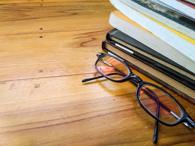 Glasses and books on a wooden table with copy space