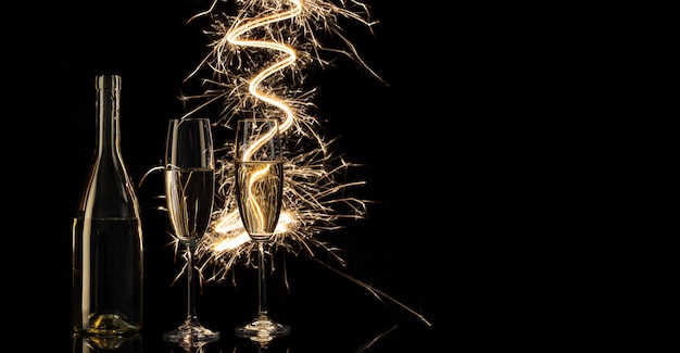 Foto bicchieri e una bottiglia di champagne nelle brillanti luci del bengala