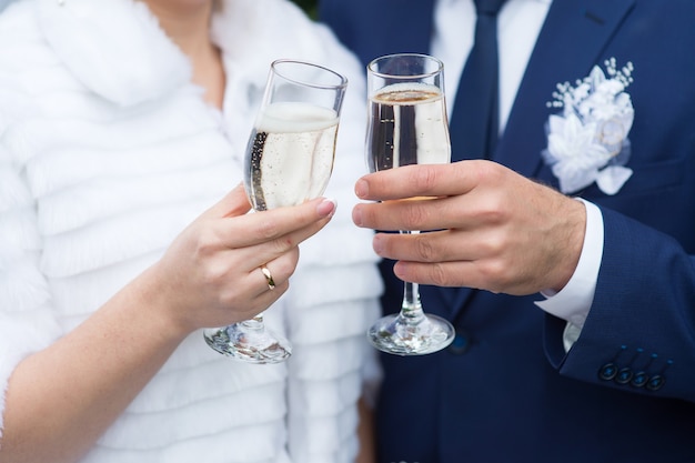 Glasses of the bride and groom close-up with champagne