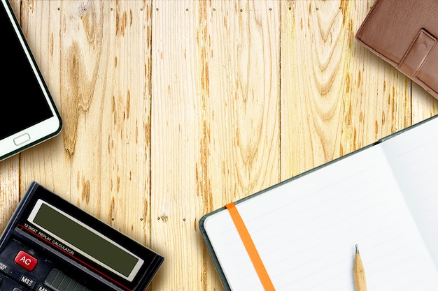 Glasses, calculator and brown pencil on notebook, top view,