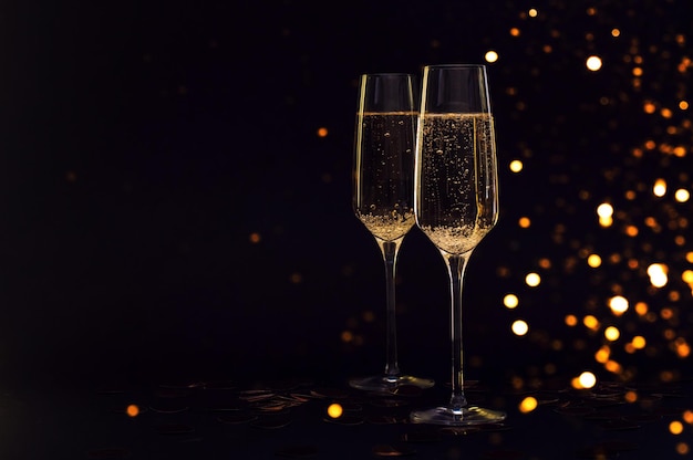 glasses of champagne with black background and lights