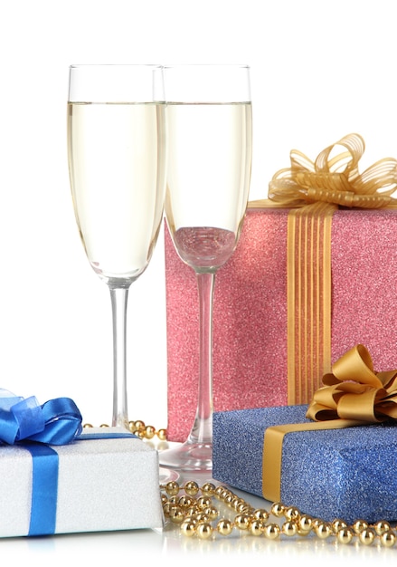 Glasses of champagne with gift boxes isolated on white