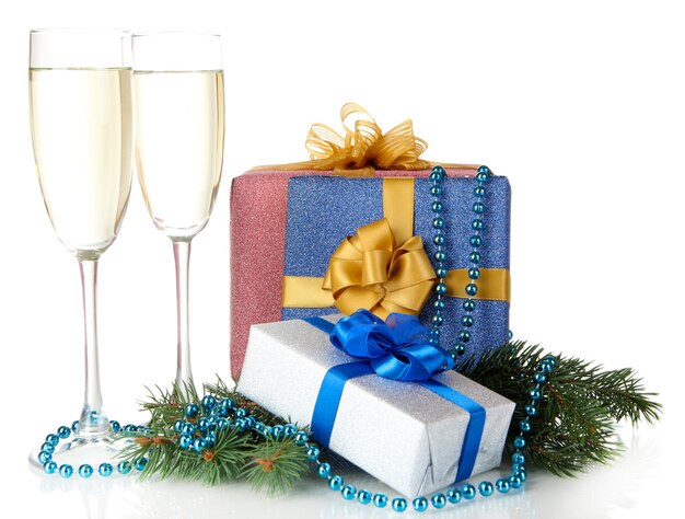 Glasses of champagne with gift boxes isolated on white