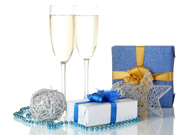 Glasses of champagne with gift boxes isolated on white