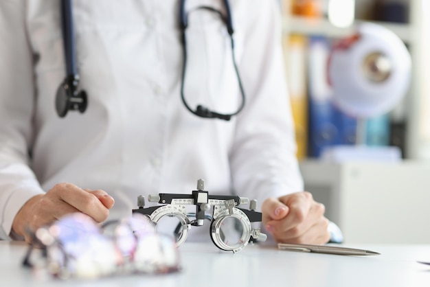 Glasses for checking vision lying on table near doctor ophthalmologist closeup