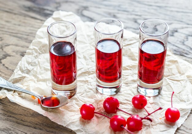 Glasses of cherry brandy with cocktail cherries