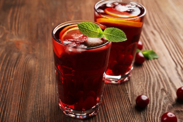 Glasses of cherry juice on wooden background