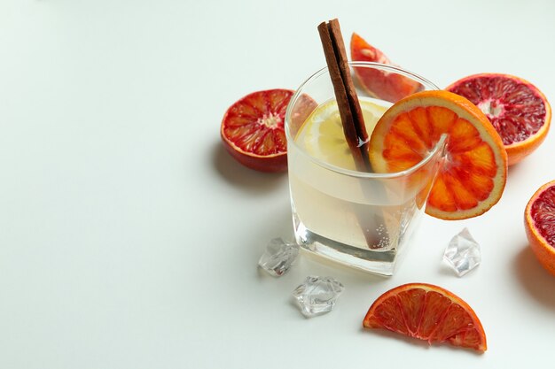 Glasses of cocktail with citrus on white background