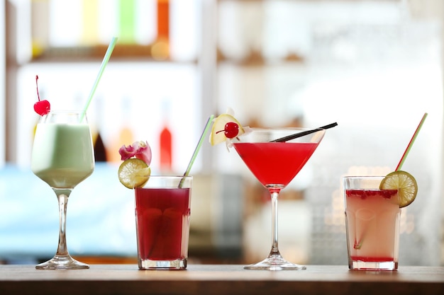 Glasses of cocktails on bar background