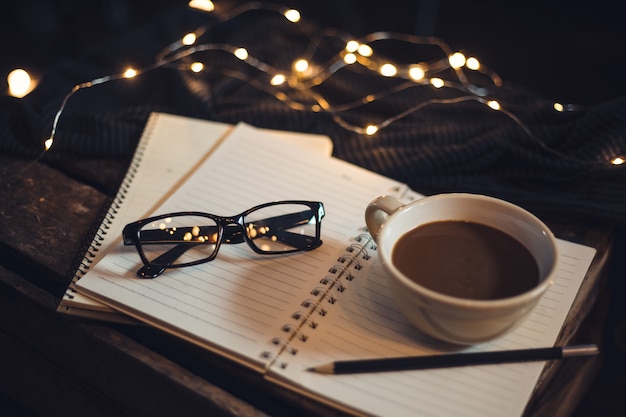 Glasses and coffee are placed on the notebook.